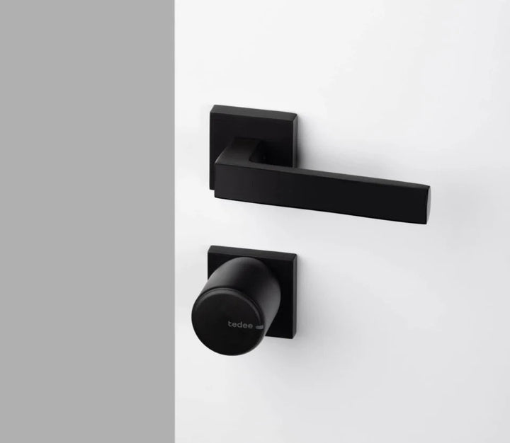 Smart digitalt dörrlås tedee Pro Svart monterat på vit dörr